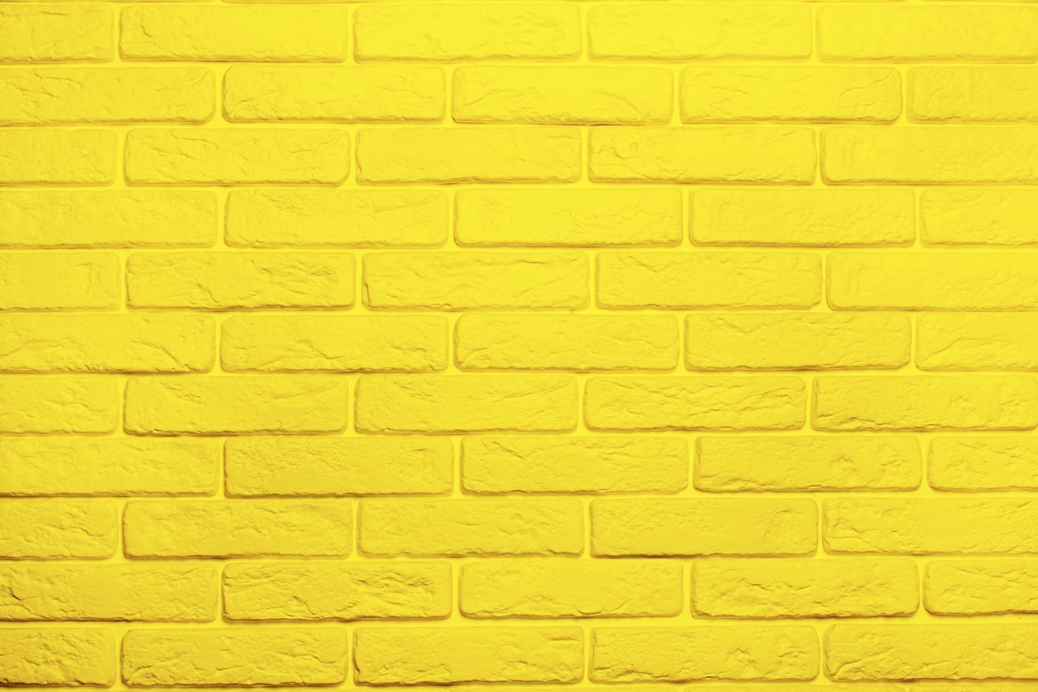 Yellow brick wall background. Trend color 2021 yellow